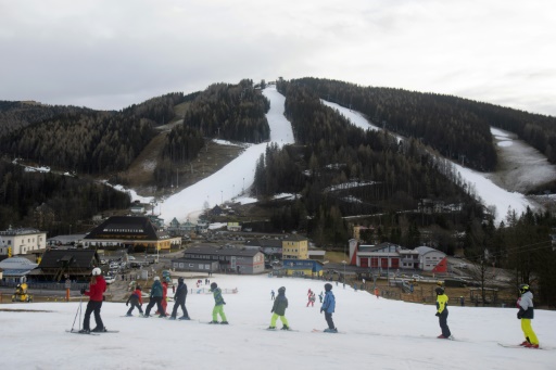 Alpine tourists ski amid brown hillsides