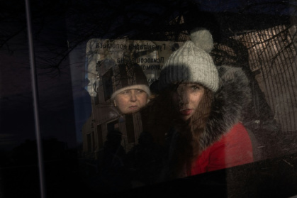 Anna (R), 21, and her mother (L) sit in a minivan as they wait at an evacuation point outside the city, in the eastern Donetsk region, on December 14, 2024, as Russian troops advanced close to the city.