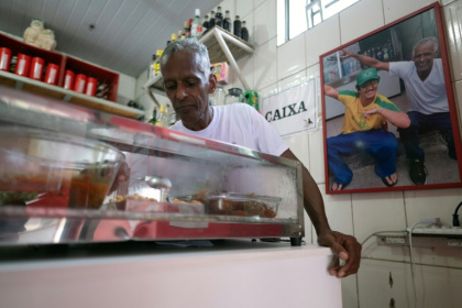 Ronaldo Teixeira, owner of Lacador, is pictured at the bar next to a photo of him with singer Bruno Mars