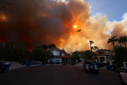 A fast-movning wildfire in the suburbs of Los Angeles sparked panicked evacuations and traffic gridlock as strong winds spread flames and thick smoke