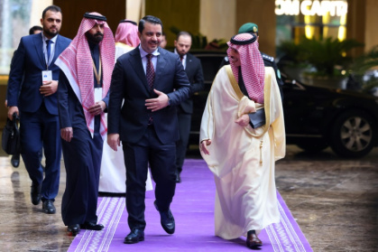 Saudi Foreign Minister Prince Faisal bin Farhan (R) welcomes his Syrian counterpart Asaad al-Shaibani (C) before attending the talks