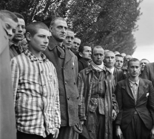 French prisoners at the Dachau concentration camp near Munich observe a minute's silence after its liberation in 1945