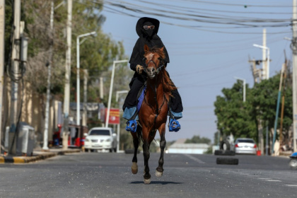 Shukri Osman Muse, Somalia's first female equestrian, rides through the streets of the capital Mogadishu