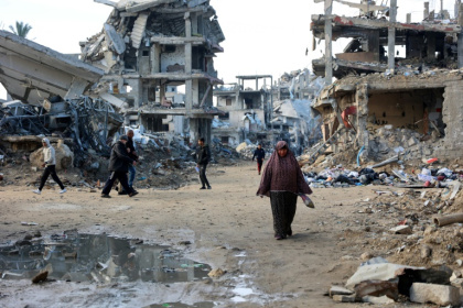 Palestinians walk amid the destruction in the Shujaiya neighbourhood of Gaza City