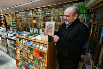 A bookseller shows a volume that was reportedly banned during the rule of Syria's ousted president Bashar al-Assad