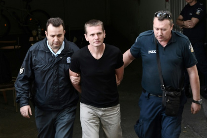 Russian Alexander Vinnik (C) is escorted by police officers as he arrives at a courthouse in Thessaloniki, Greece in 2017