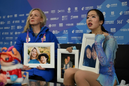 Thailand’s Teekhree Silpa-Archa (R) holds the photos of US figure skaters who died in the Washington plane crash