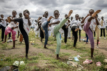Young refugee girls practice taekwondo kicks as they warm up for a recent performance in Kalobeyei Young refugee girls practice taekwondo kicks as they warm up for a recent performance in Kalobeyei
